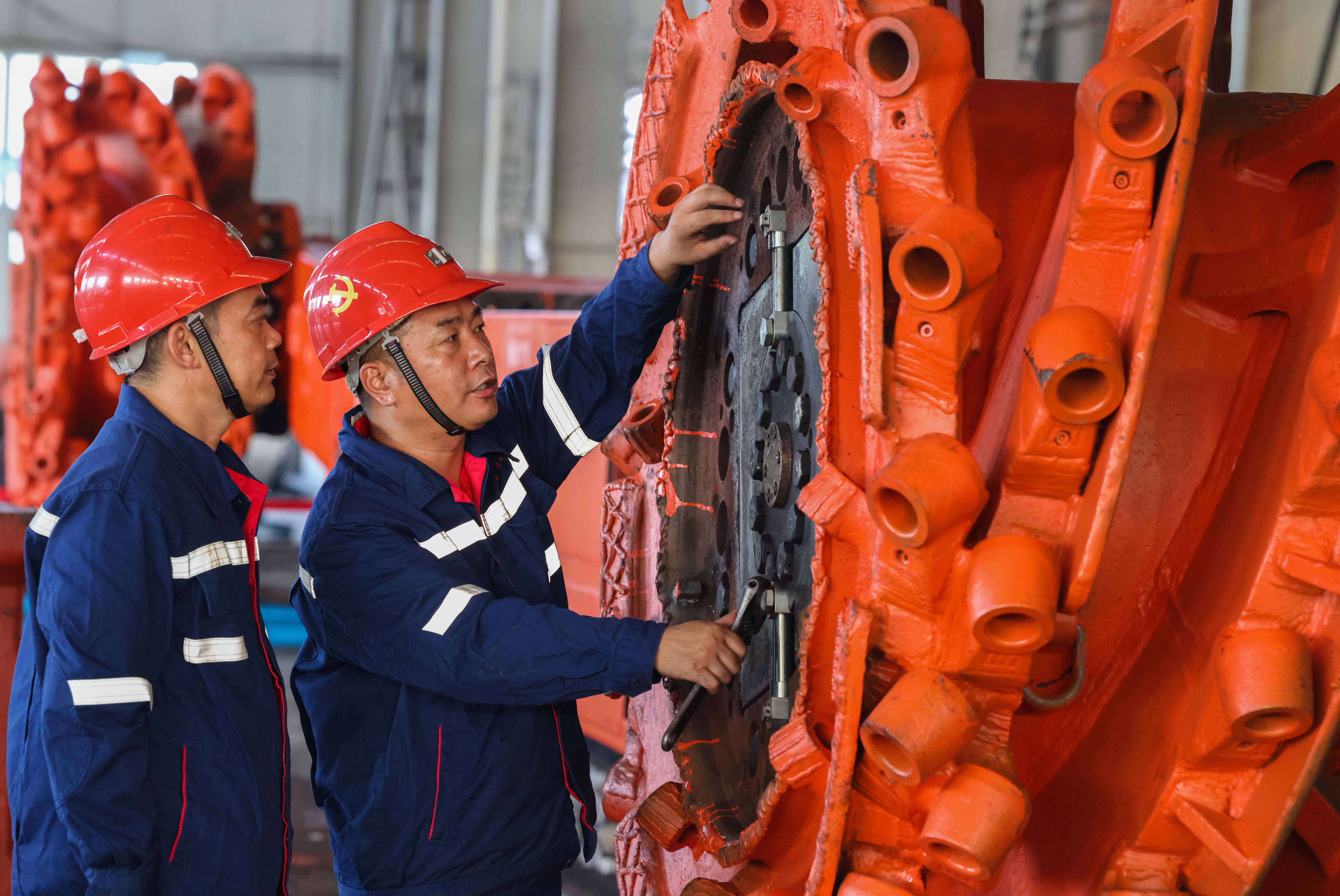 AGGAME矿业集团“工匠大师工作室”核心成员王忠才和徒弟共同探讨综采机维修技巧。：楣馍